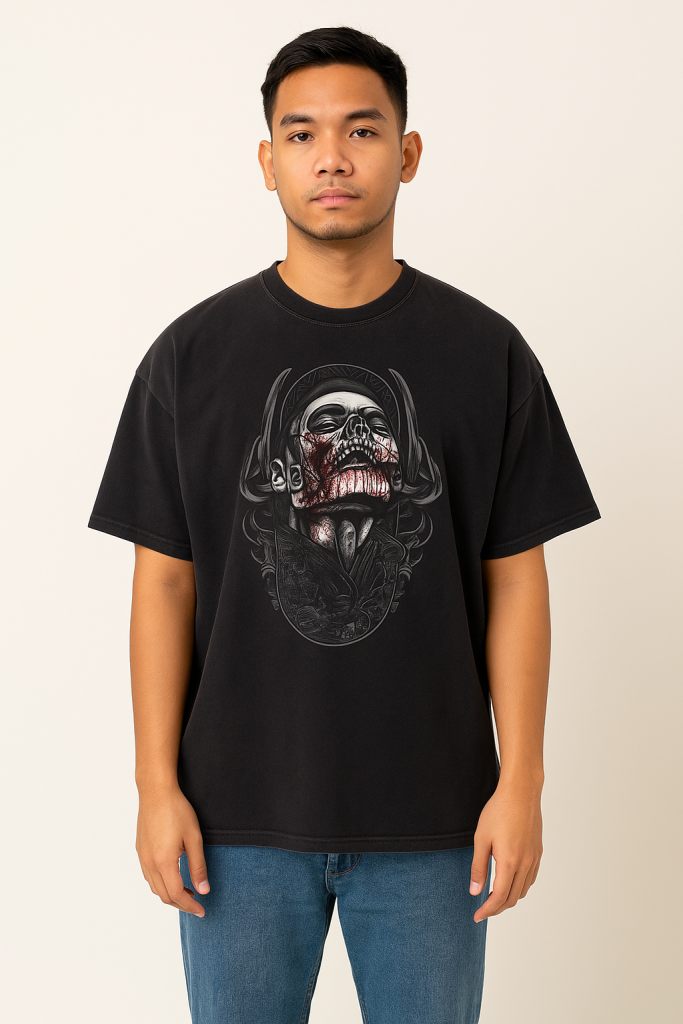 A man with short hair and a neutral expression wears the Victim - Vintage Washed Hand-Frayed T-Shirt, which features a gothic skull and screaming face graphic, against a plain background. He pairs it with blue jeans.