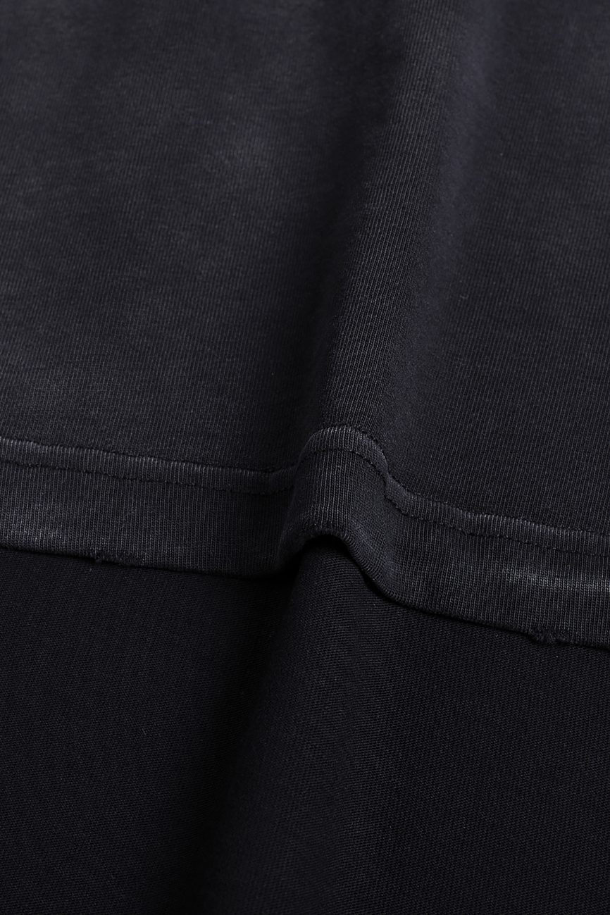 Close-up of the black Fusion Atom Vintage Washed Hand-Frayed T-Shirt, highlighting its horizontal seam and detailed stitching that reflect the textured craftsmanship of affordable luxury apparel.