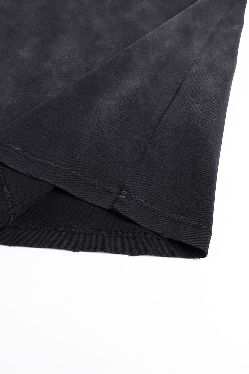 A close-up of the hem and side seam of the Fusion Atom - Vintage Washed Hand-Frayed T-Shirt in black, shown on a white background. The soft, slightly faded fabric showcases the comfort and style of affordable luxury apparel.