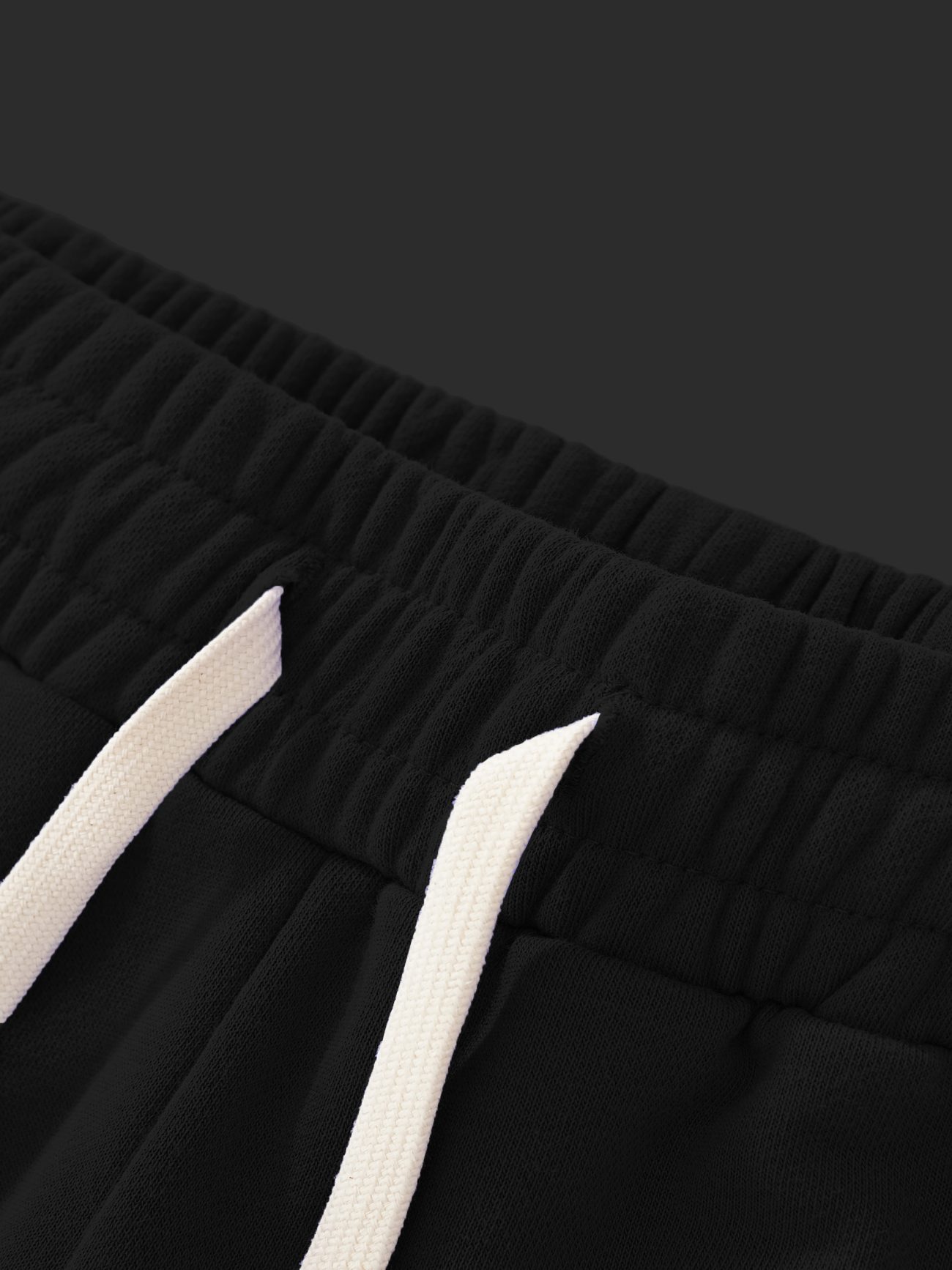 Close-up of the waistband of Sun Fade Raw Edge Cotton Shorts with an elastic band and white drawstrings, showcasing affordable luxury and attention to comfort and detail against a dark background.