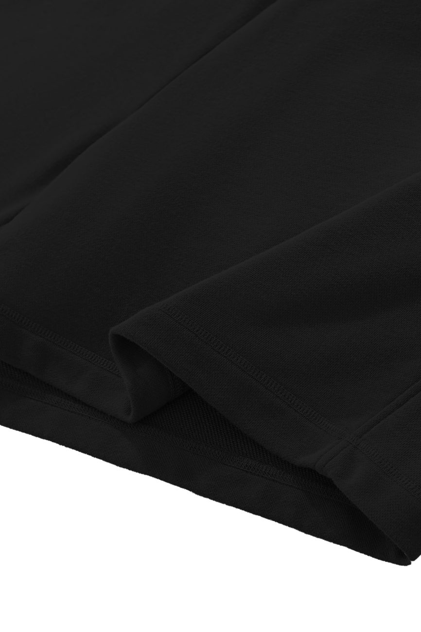 Close-up of the hem and fabric texture of our Sun Fade Raw Edge Cotton Shorts, highlighting clean stitching and smooth black cotton, with just the lower portion shown against a white background.