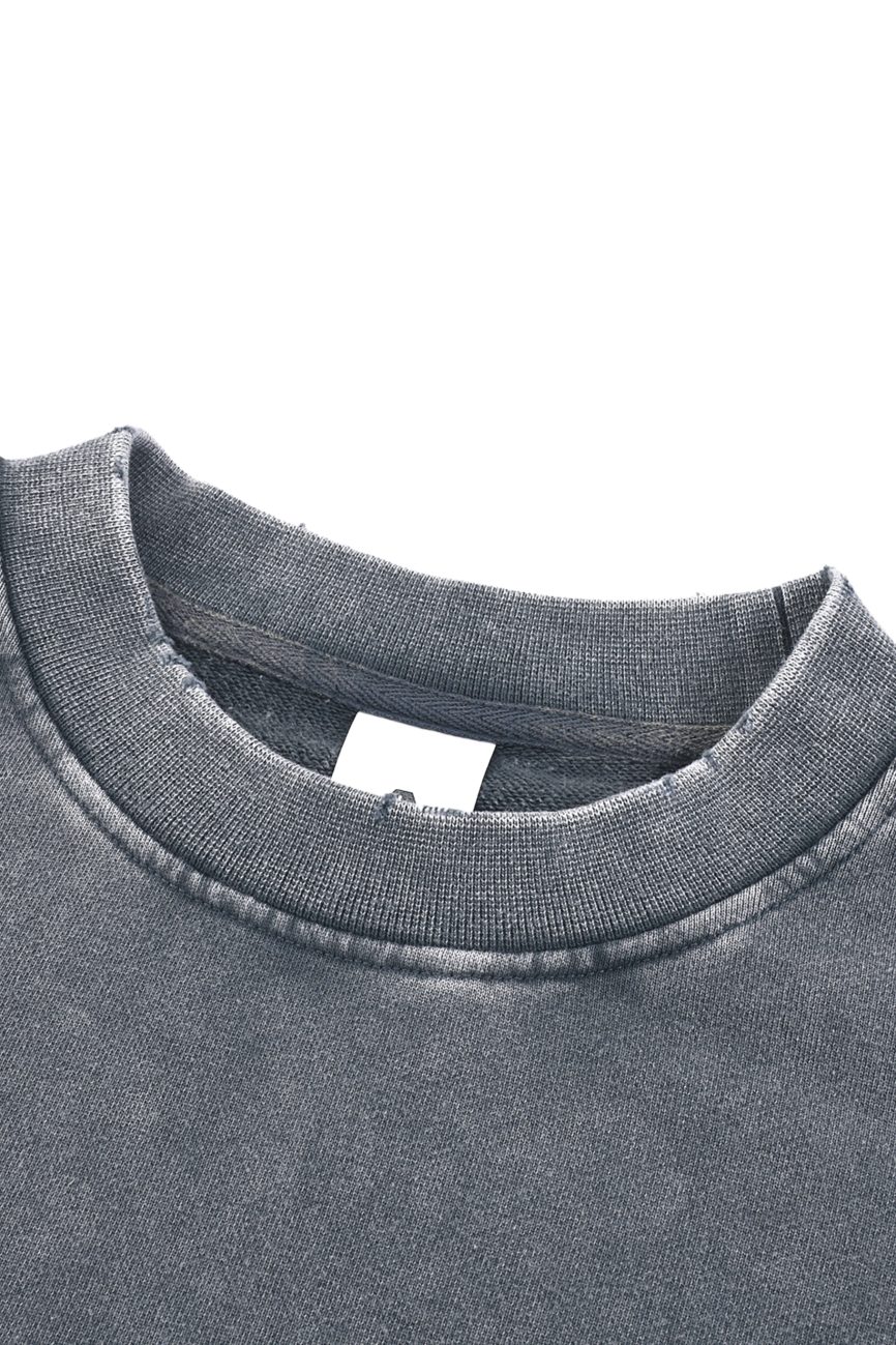Close-up of a Womens Snow Washed Raw Edge Cropped Sweatshirt in grey, featuring a ribbed crew neckline and white blank tag inside the collar. The fabric looks soft with a slightly worn, vintage finish.