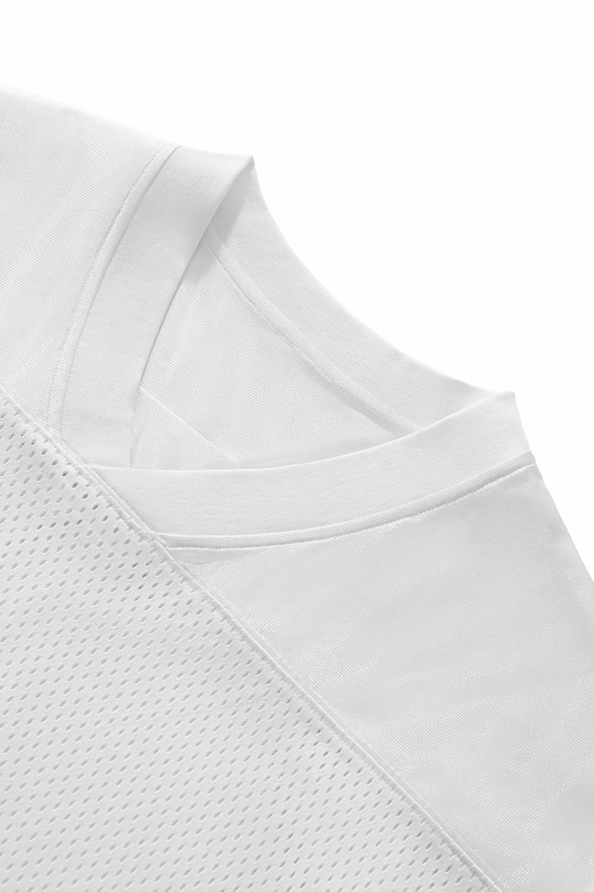 Close-up of the upper part of our Fifteen - light Taped Mesh T-Shirt, showcasing the collar, shoulder seam, and a mesh-textured section for an elevated everyday look from our Affordable Luxury Clothing line.