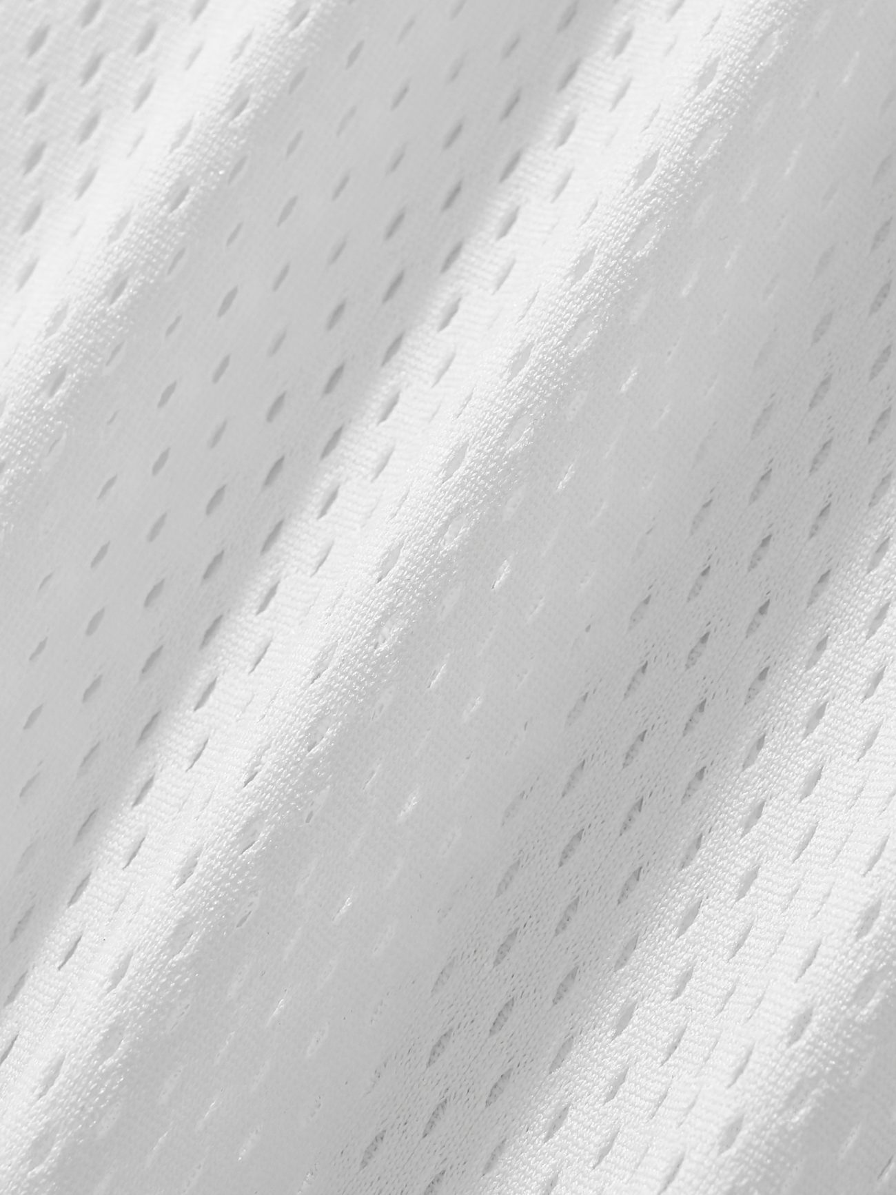 Close-up of the Fifteen - light Taped Mesh T-Shirts white, breathable fabric featuring small, evenly spaced holes and diagonal ridges—lightweight comfort and style ideal for affordable luxury sportswear or activewear.