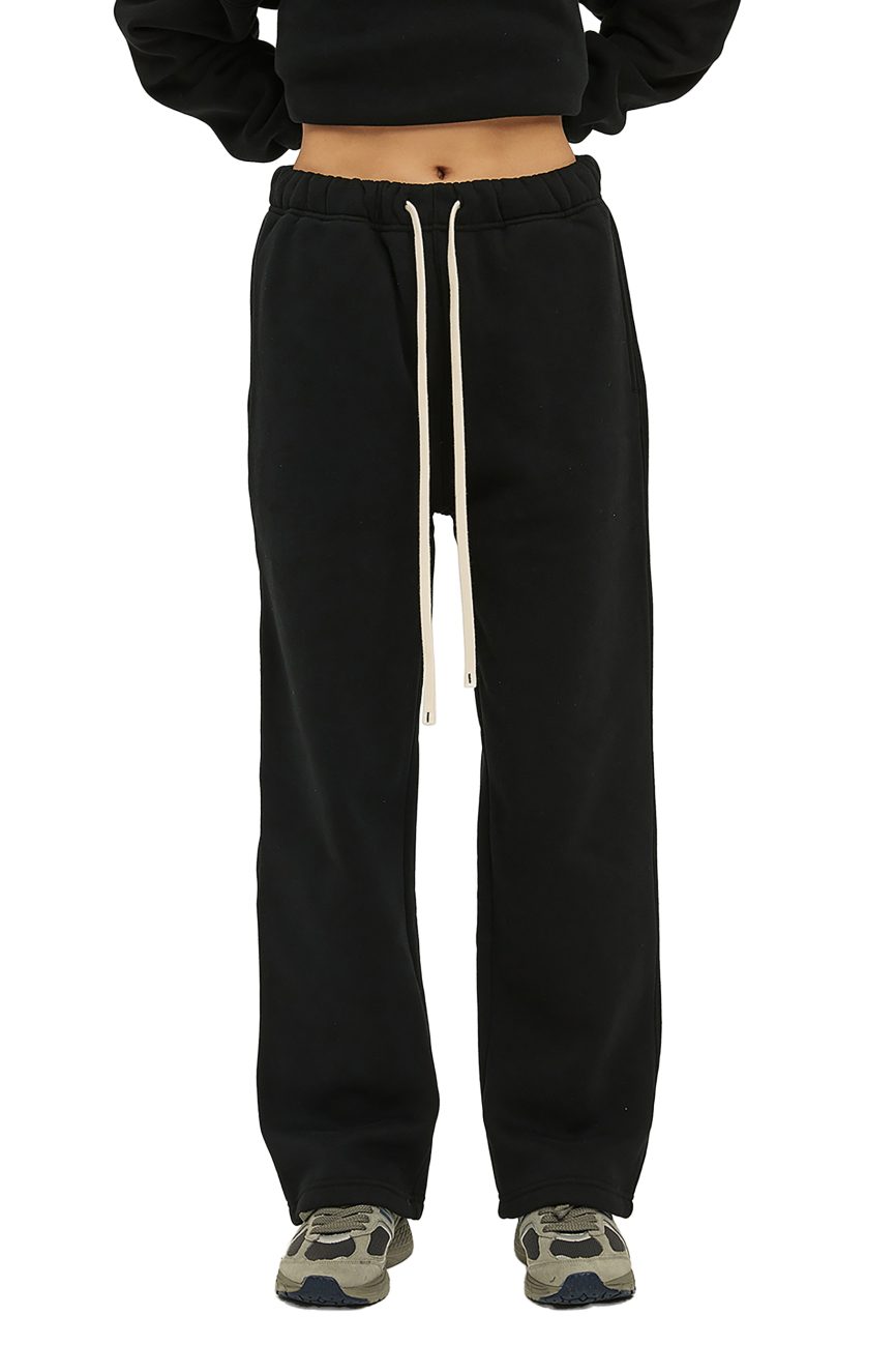 Person wearing Fusion Streetwear Unisex Solid Color Fleece Straight Leg Pants with white drawstrings, a black cropped top, and gray sneakers poses against a white background—an easy look inspired by affordable luxury.