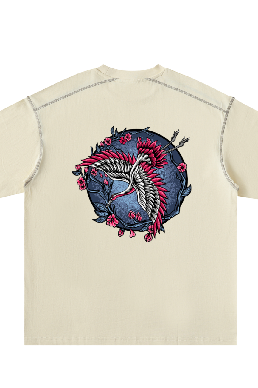 The Crane - Oversized Contrast-Stitched Cotton Tee features a beige color and a circular back design with two stylized cranes, red accents, pink cherry blossoms, and dark blue foliage—an affordable luxury piece for your wardrobe.
