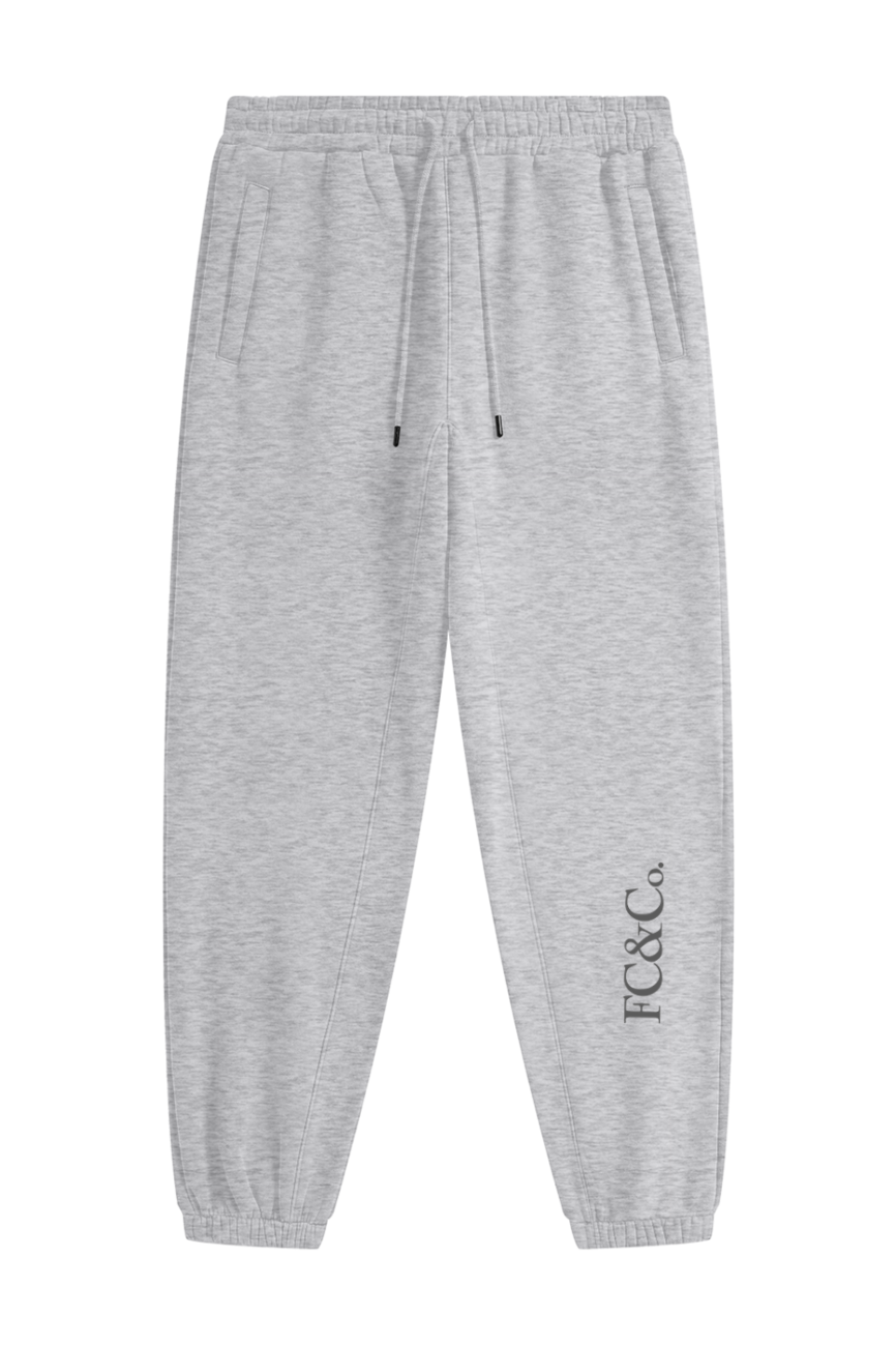 Streetwear Unisex Fleece Joggers in light gray with an elastic waistband, drawstring, and side pockets. FC&Co. is printed vertically on the left ankle—an affordable luxury piece for everyday comfort.