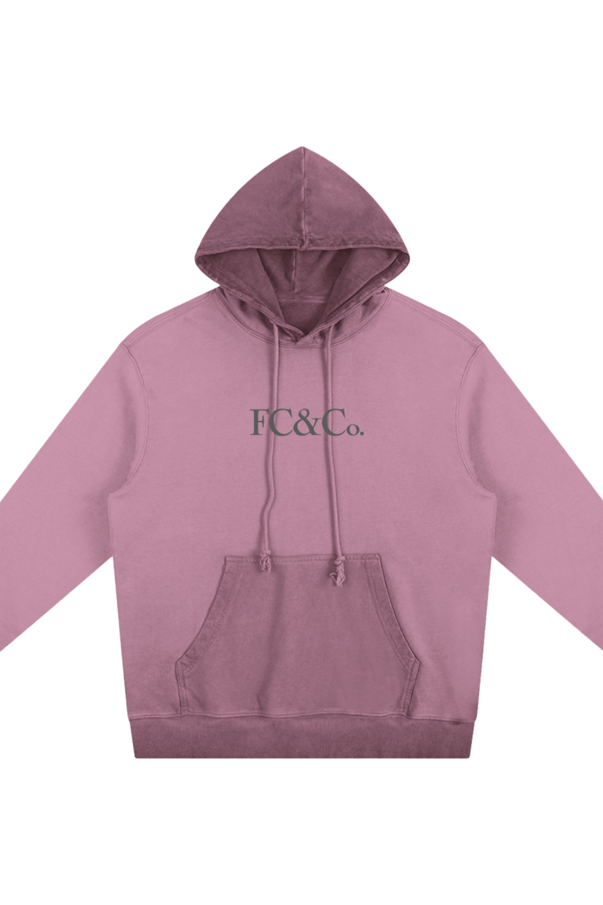 The FC&Co. Ombre Vintage Stone Washed Colorpointed Hoodie features a mauve shade, front pocket, drawstring hood, and green FC&Co. chest print—an ideal choice for those seeking affordable luxury style.