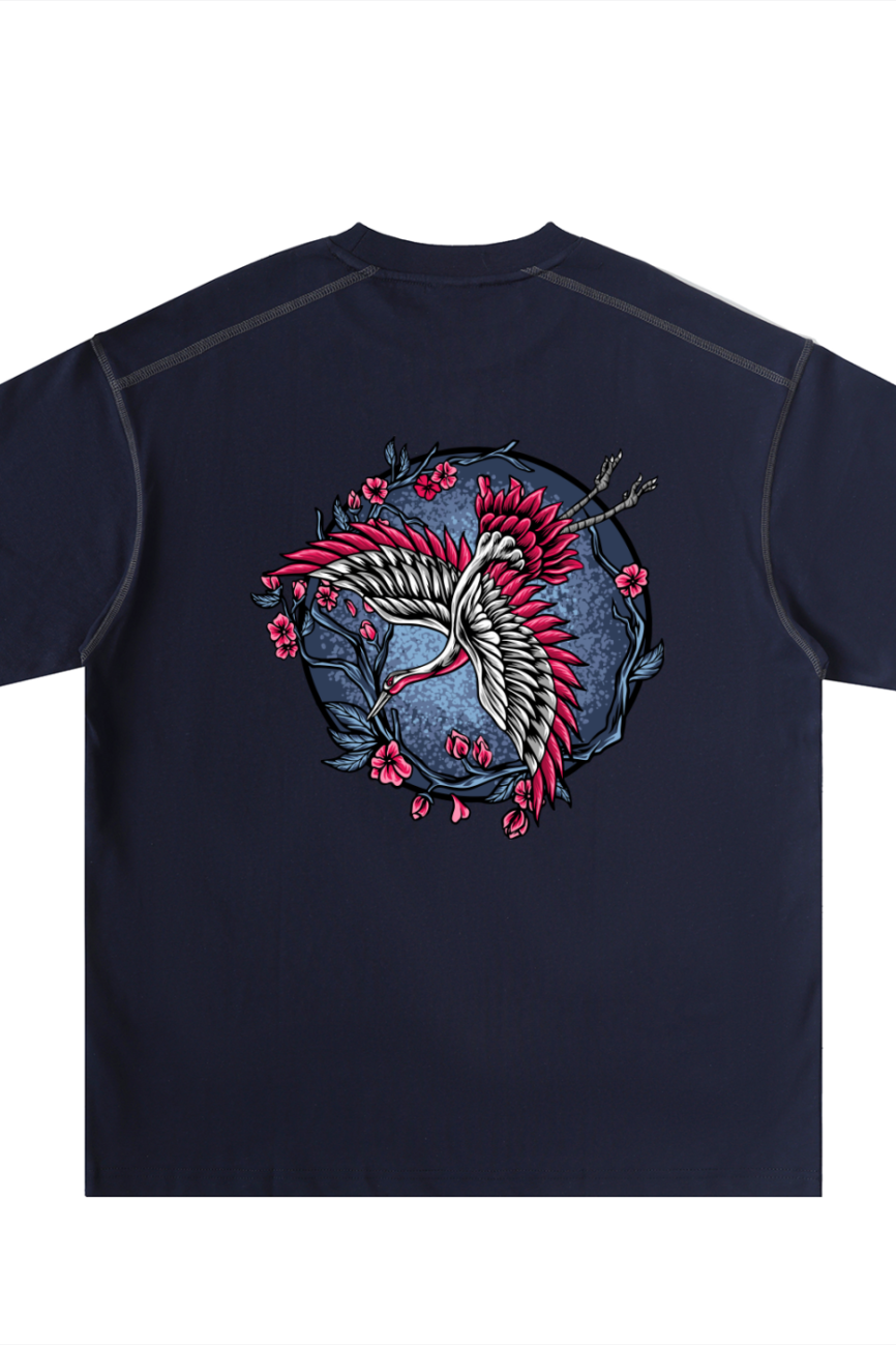 The Crane - Oversized Contrast-Stitched Cotton Tee features a navy blue color with a large, vibrant back design of two white cranes with red accents, surrounded by pink cherry blossoms—an affordable luxury statement piece.