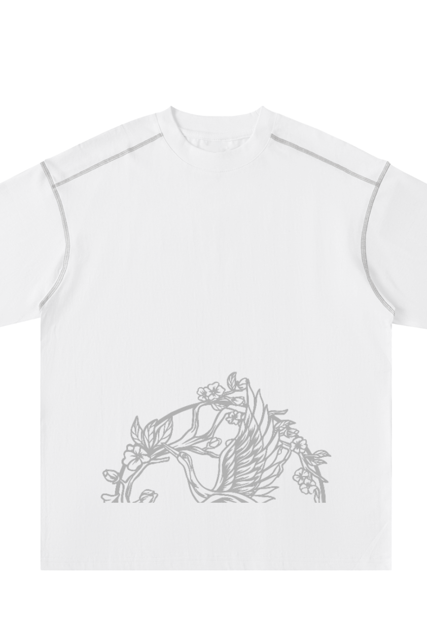 The Crane - Oversized Contrast-Stitched Cotton Tee is a white short-sleeve shirt with a light gray bird and floral line drawing on the lower front—perfect for those who appreciate affordable luxury fashion.