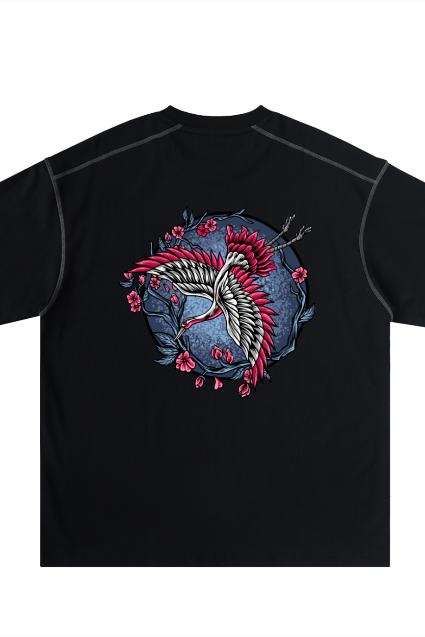 Discover affordable luxury with the Crane - Oversized Contrast-Stitched Cotton Tee in black, showcasing a white crane with red accents, pink flowers, and branches on a blue circle backdrop on the back.