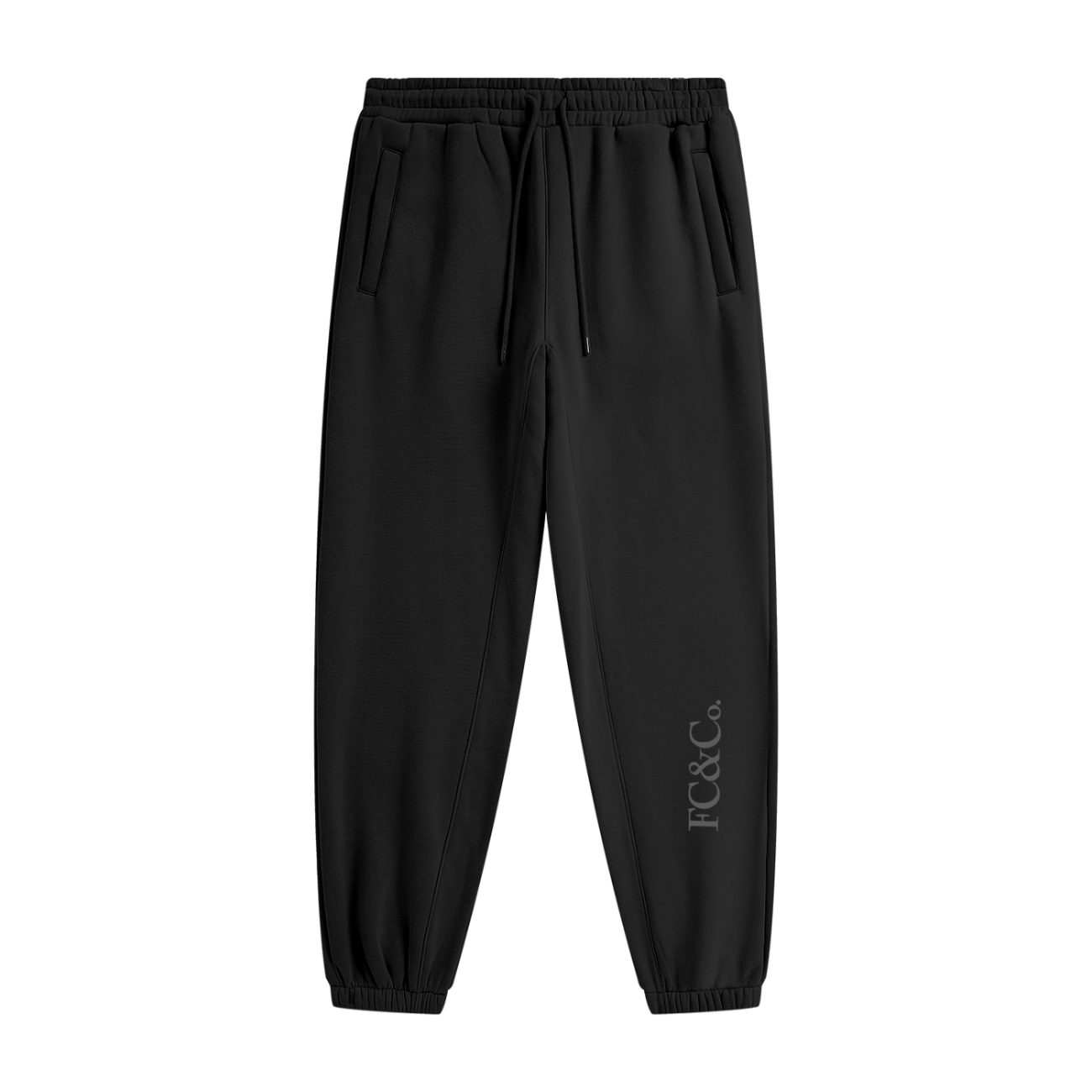 Streetwear Unisex Fleece Joggers feature an elastic waistband, drawstring, two side pockets, cuffed ankles, and subtle FC&Co. print near the left ankle—offering comfort and affordable luxury in black.