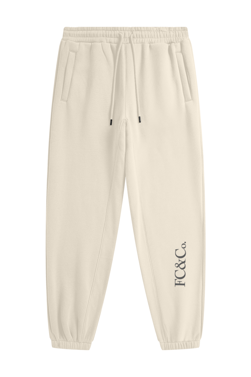Streetwear Unisex Fleece Joggers in beige feature an elastic waistband, drawstring, side pockets, and FC&Co. print by the left ankle—ideal affordable luxury for those who value both comfort and style.