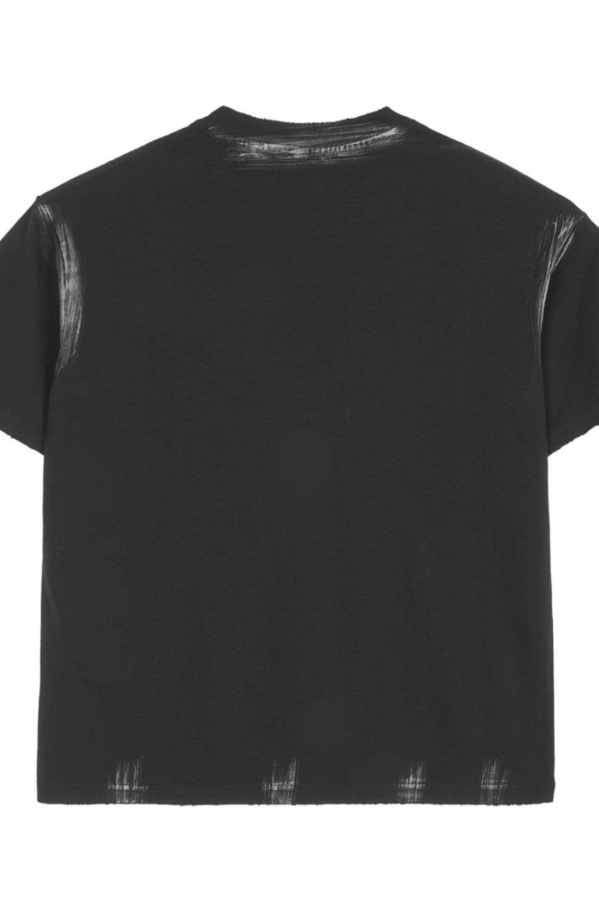 The Hand Brushed T-shirt is a plain black short-sleeve tee seen from the back, featuring subtle white distressed marks along the collar, sleeve edges, and hem—showcasing affordable luxury with understated brushing details.