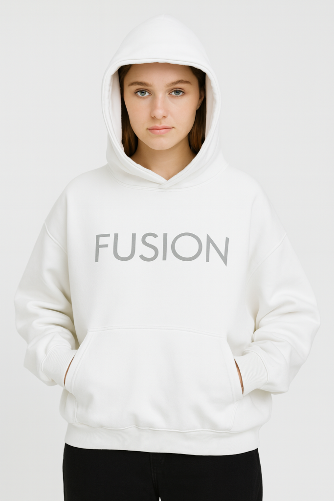 A person stands facing forward, hands in the pocket, hood up, wearing the Fusion Oversize Fleeced Hoodie with FUSION printed on the front—an embodiment of affordable luxury—against a plain white background.