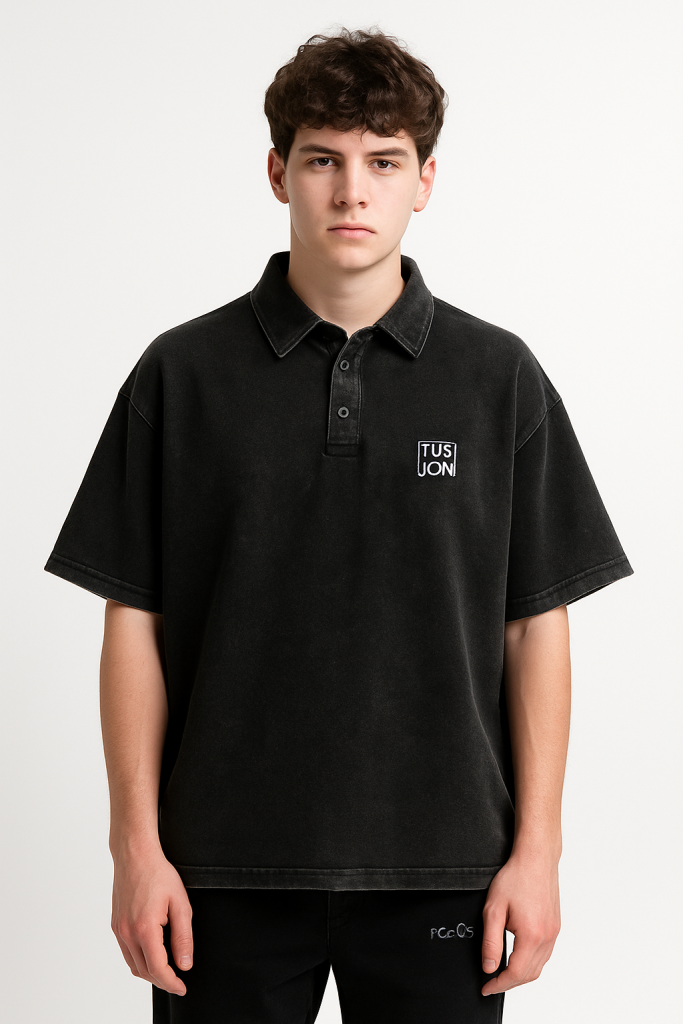 A young man with short brown hair wears a loose-fitting Heavyweight Snow-Washed Polo T-Shirt from TUSUON, representing affordable luxury clothing, standing against a plain white background.