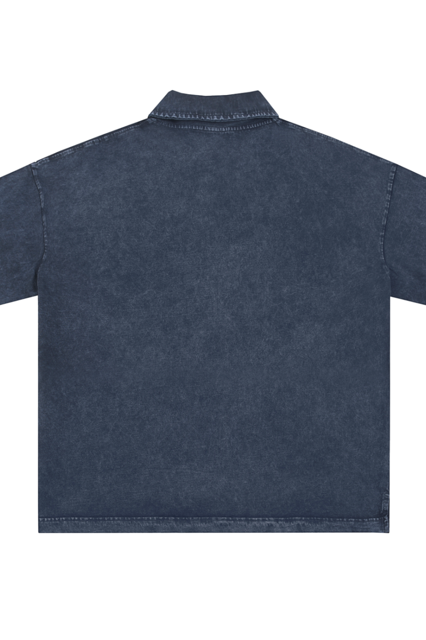 Back view of the Heavyweight Snow-Washed Polo T-Shirt, a short-sleeve, collared denim shirt in dark blue, shown flat on a white background. Visible stitching and straight hem make this an affordable luxury essential.