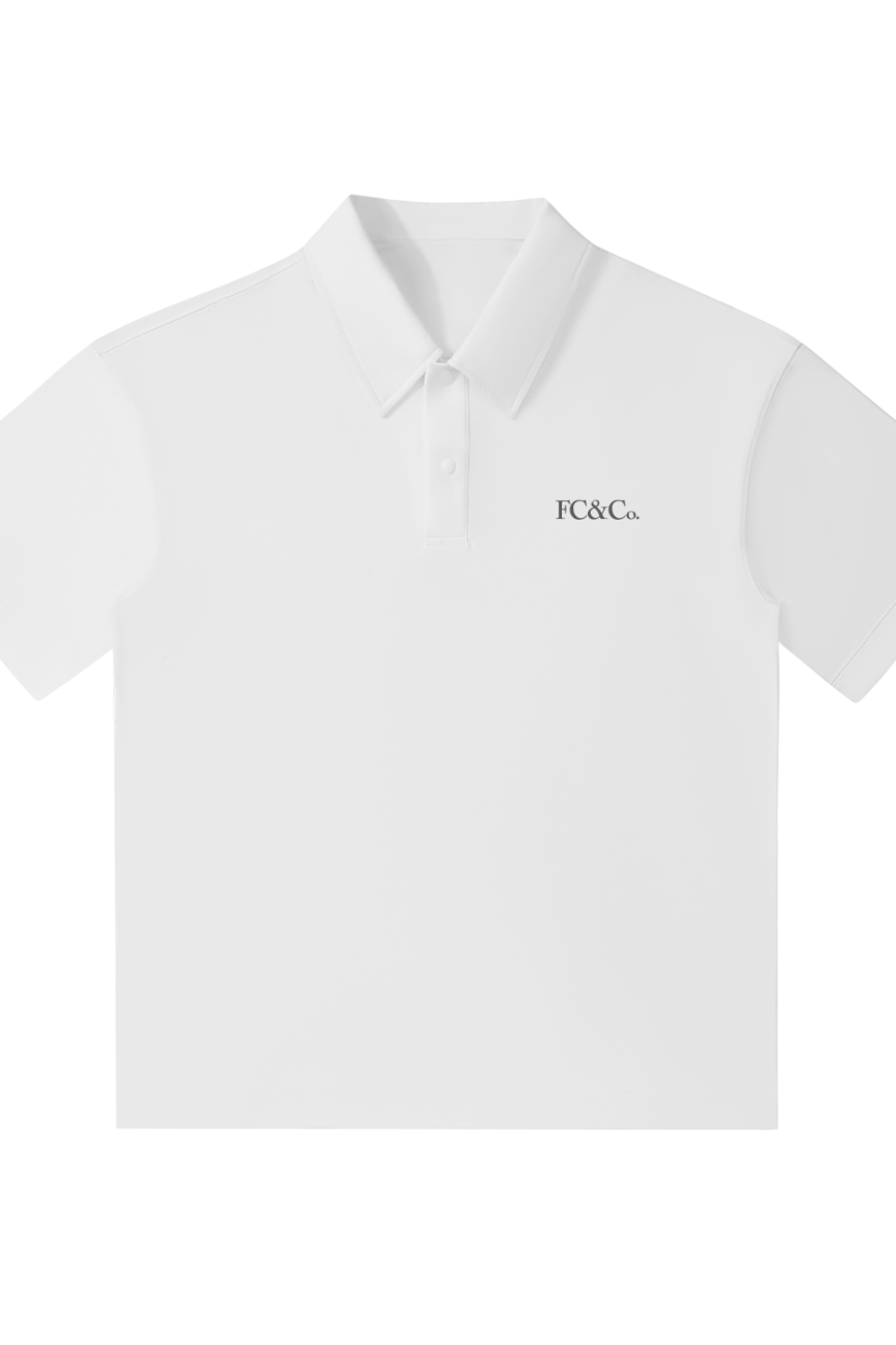 The FC&Co. Drop Shoulder Short-Sleeve Polo is a crisp white polo with a collar and buttons, featuring small black F C & Co. text on the left chest—an essential for any affordable luxury wardrobe.