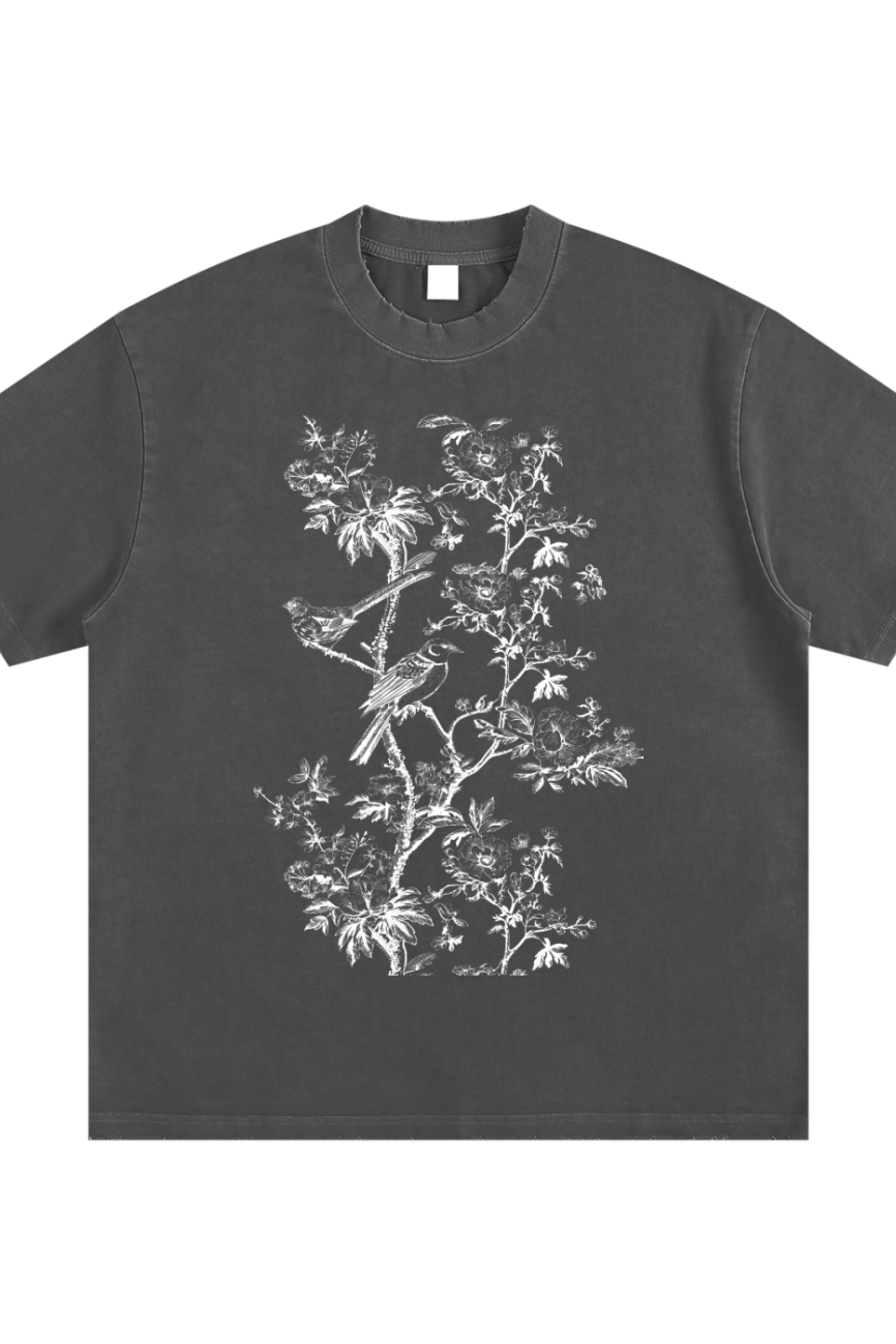 The Toile De Jouy - Heavyweight Vintage Washed Frayed T-Shirt is a black oversized tee with a detailed white line drawing of birds on leafy branches and flowers—a stylish, affordable luxury piece.