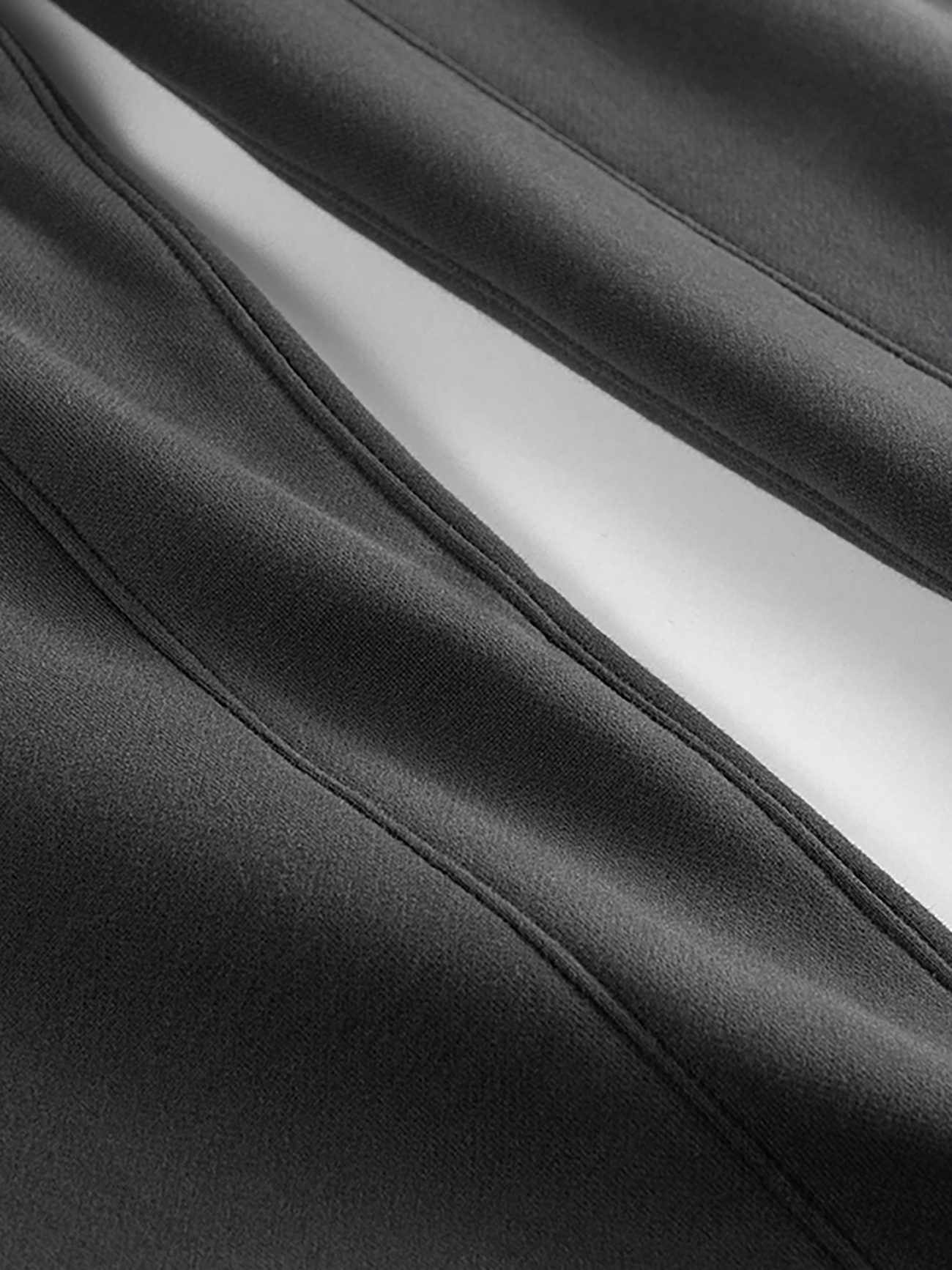 Close-up of black fabric with visible stitching and a white stripe running through the center, highlighting the sleek, modern design of Streetwear Unisex Fleece Joggers—affordable luxury with style and comfort.