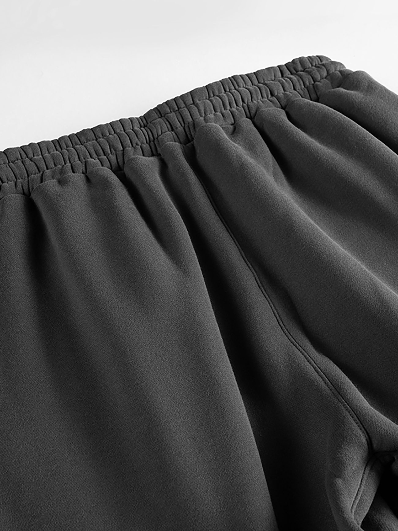 Close-up of the waistband and upper section of Streetwear Unisex Fleece Joggers, featuring an elastic waist and soft, textured black fabric—an ideal example of affordable luxury streetwear.