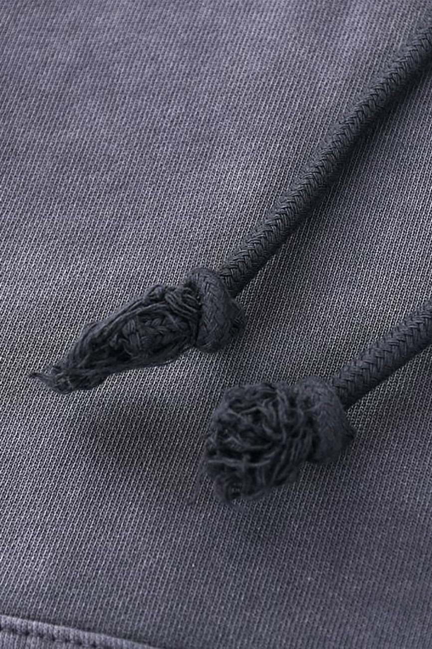 Close-up of two black hand-frayed drawstrings on dark grey fabric from the Company Heavyweight Pure Cotton Hand-Frayed Monkey Washed Hoodie, highlighting the refined details of this affordable luxury piece.
