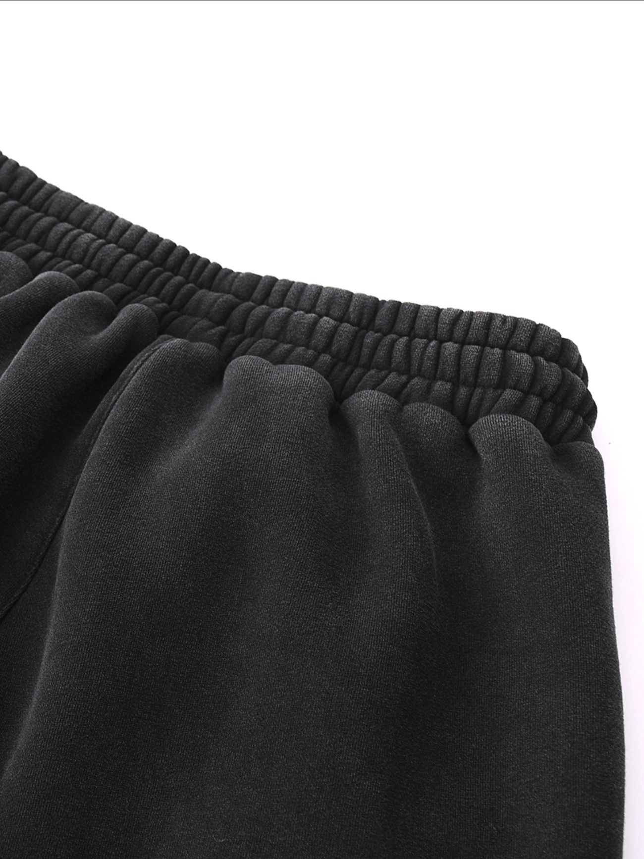 Close-up of the waistband and upper portion of the Fleeced Jogger Sweatpants, featuring a black elasticated, gathered band—perfect for those seeking affordable luxury—set against a plain white background.