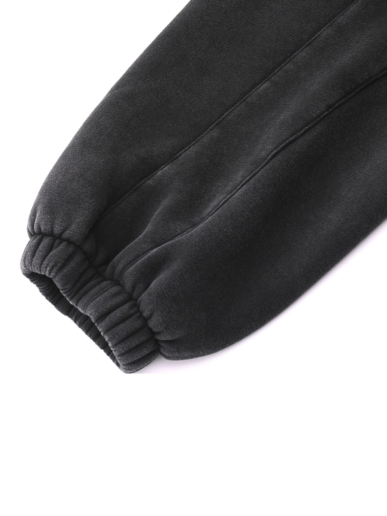 Close-up of the elastic cuff on a black Fleeced Jogger Sweatpants sleeve, set against a white background—showcasing affordable luxury style.