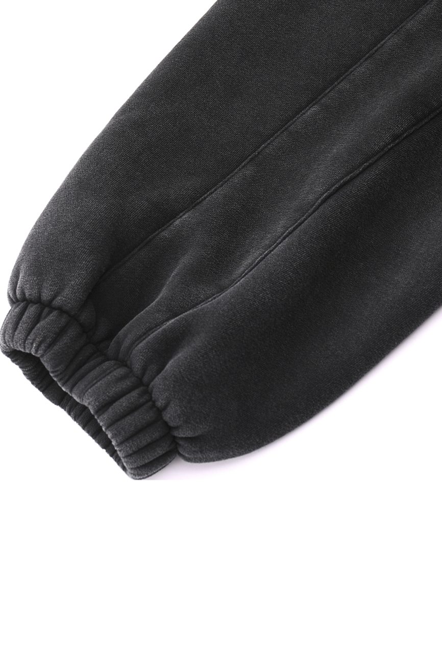 Close-up of the elastic cuff on a black Fleeced Jogger Sweatpants sleeve, set against a white background—showcasing affordable luxury style.