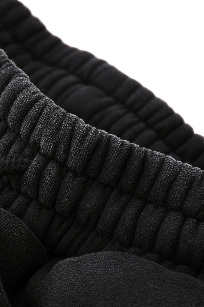 Close-up of the elastic waistband on our Fleeced Jogger Sweatpants in black—showcasing the textured fabric and meticulous stitching from our Affordable Luxury Clothing line.