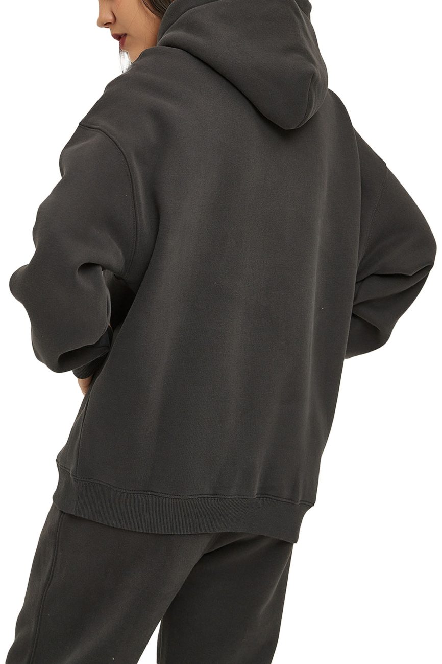 A person wears the Fusion Oversize Fleeced Hoodie and matching sweatpants—an affordable luxury look. Shown from the back with hood up and hands on hips, this outfit radiates a casual, relaxed vibe.