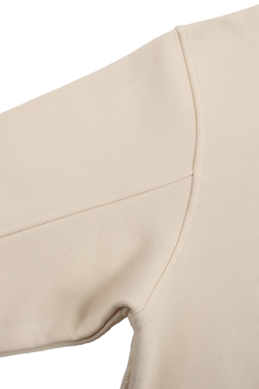 Close-up view of the upper sleeve and shoulder seam of the Fleeced High Neck Hoodie in beige, showcasing its textured fabric and detailed stitching that exemplify the craftsmanship of Affordable Luxury Clothing.