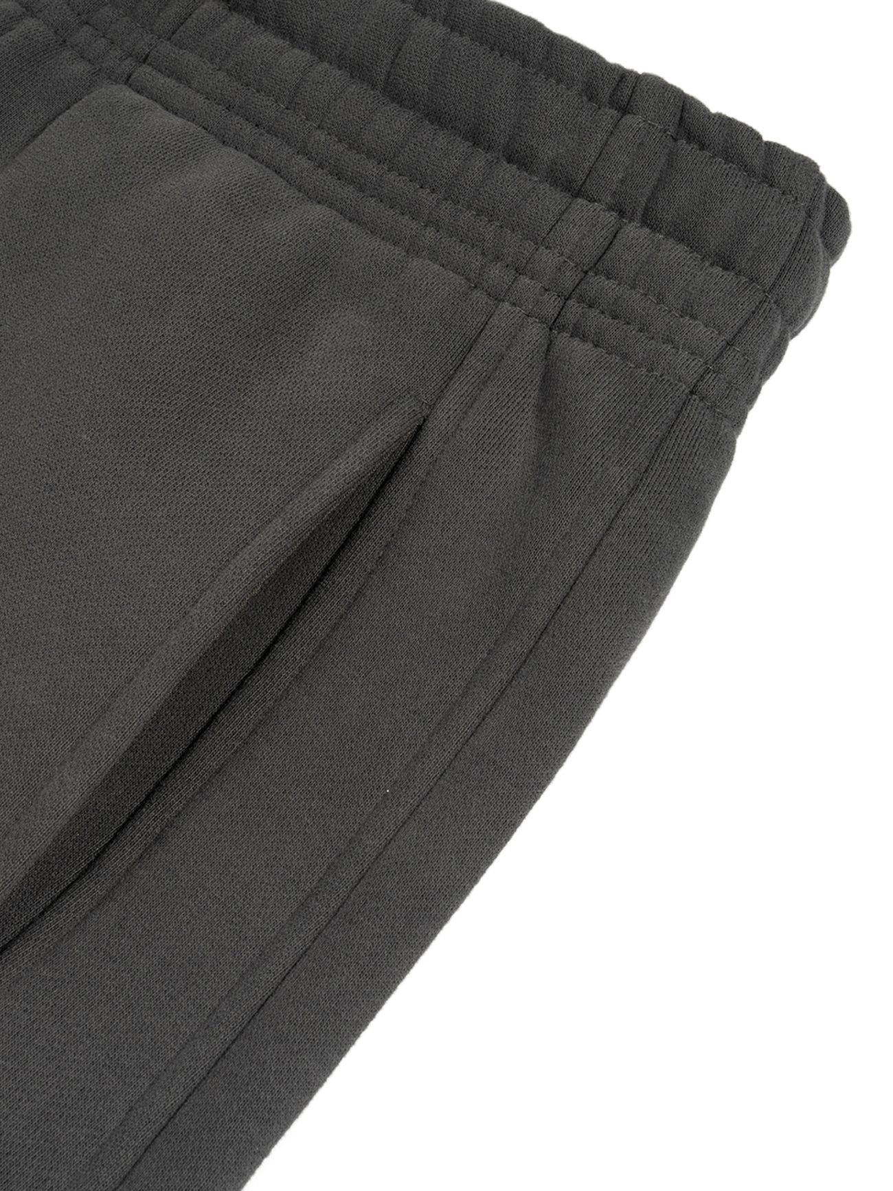 Close-up of the waistband and pocket of Sunfade Curved Blade Fleece Sweatpants, featuring an elastic waistband and side seam pocket for affordable luxury in dark gray.