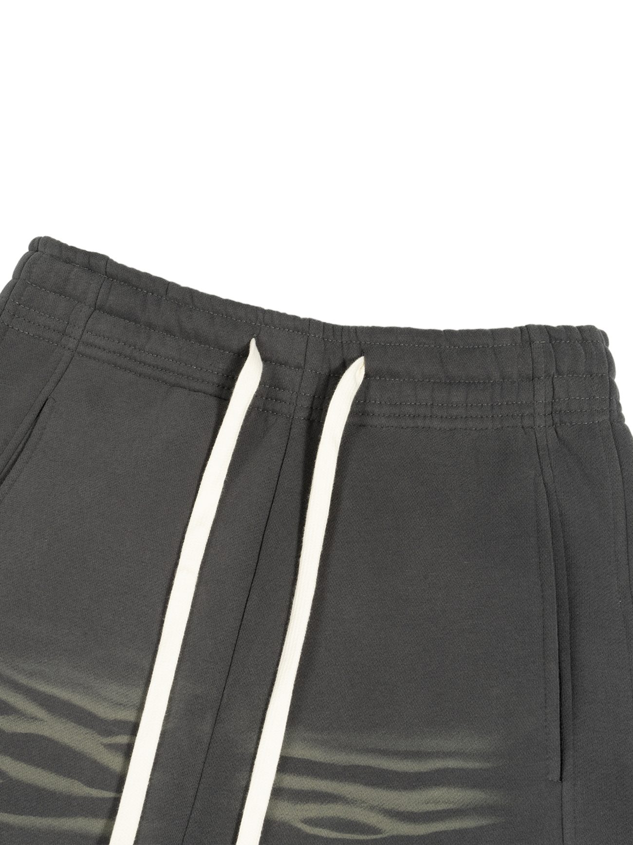 Close-up of the waistband of our Sunfade Curved Blade Fleece Sweatpants from the Affordable Luxury Clothing line, in dark gray with white drawstrings and a subtle light gray wavy pattern near the pockets.