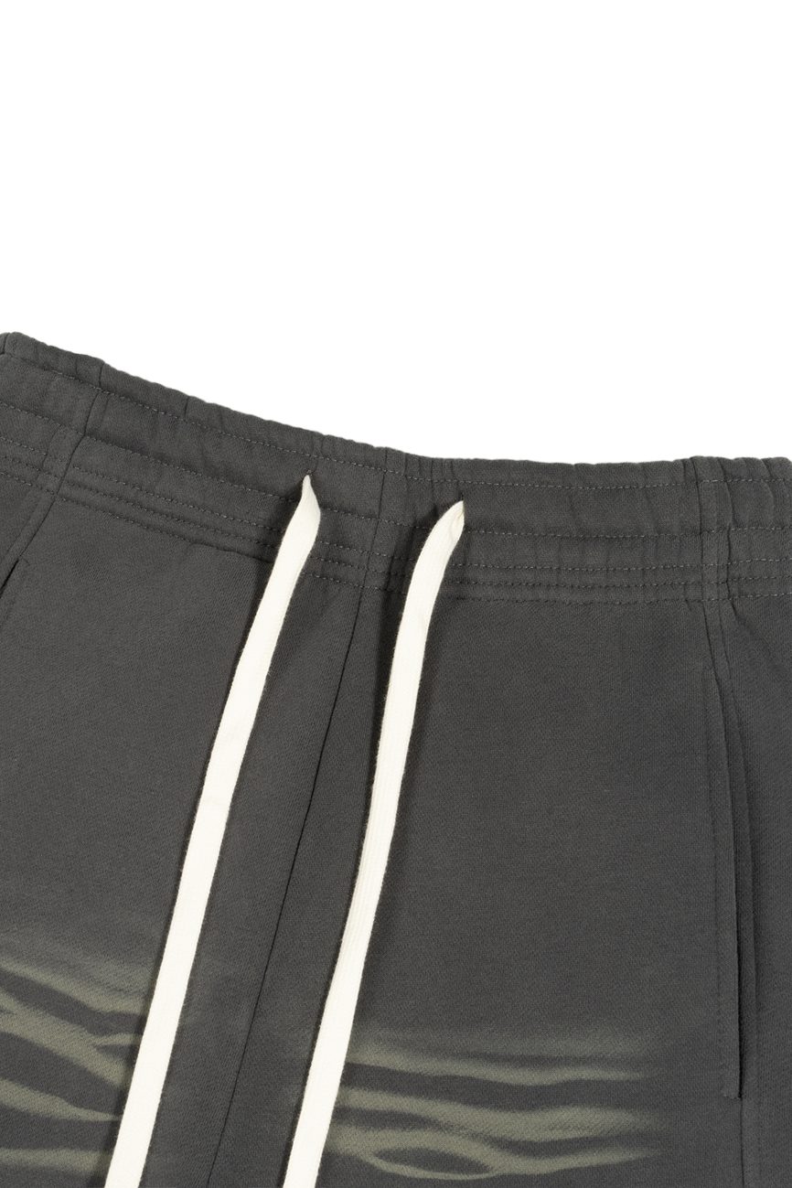 Close-up of the waistband of our Sunfade Curved Blade Fleece Sweatpants from the Affordable Luxury Clothing line, in dark gray with white drawstrings and a subtle light gray wavy pattern near the pockets.