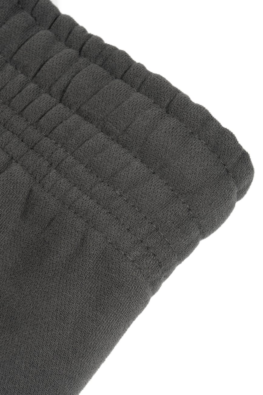 Close-up of the dark gray elastic waistband on Sunfade Curved Blade Fleece Sweatpants highlights detailed stitching and gathered fabric—showcasing affordable luxury craftsmanship.