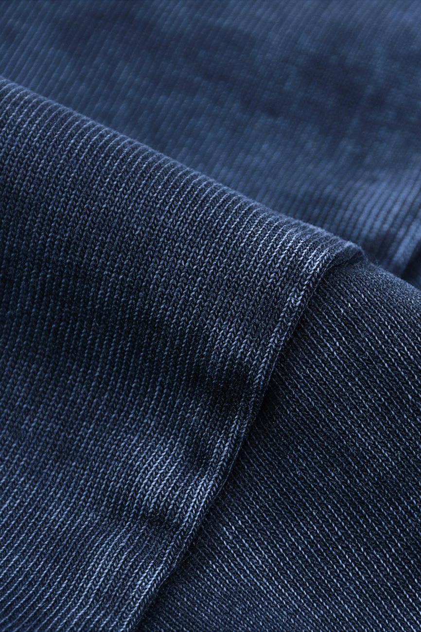 Close-up of the dark blue ribbed fabric on our Fusion Heavyweight Snow-Washed Polo T-Shirt, highlighting its soft, slightly shiny texture and fine horizontal lines, with visible seams and folds for a touch of affordable luxury.