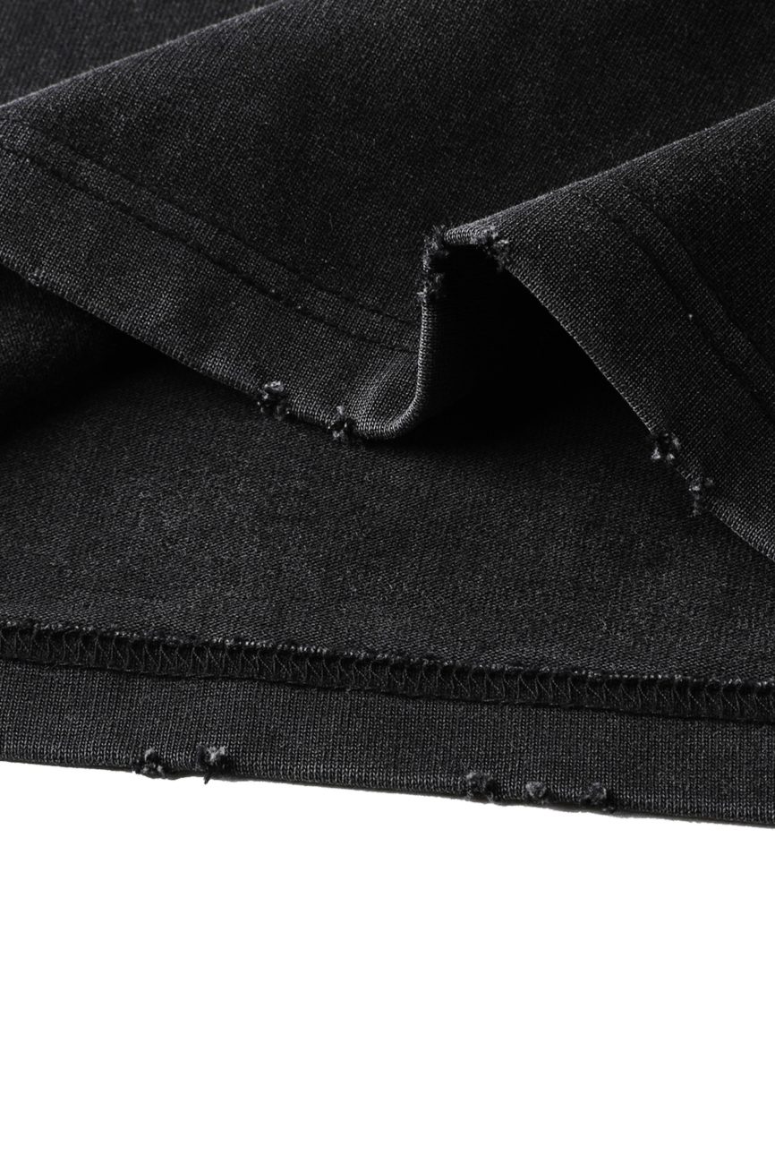 Close-up of the Toile De Jouy Heavyweight Vintage Washed Frayed T-Shirt’s black fabric with visible stitching and raw, frayed edge—showcasing affordable luxury craftsmanship in every detail.
