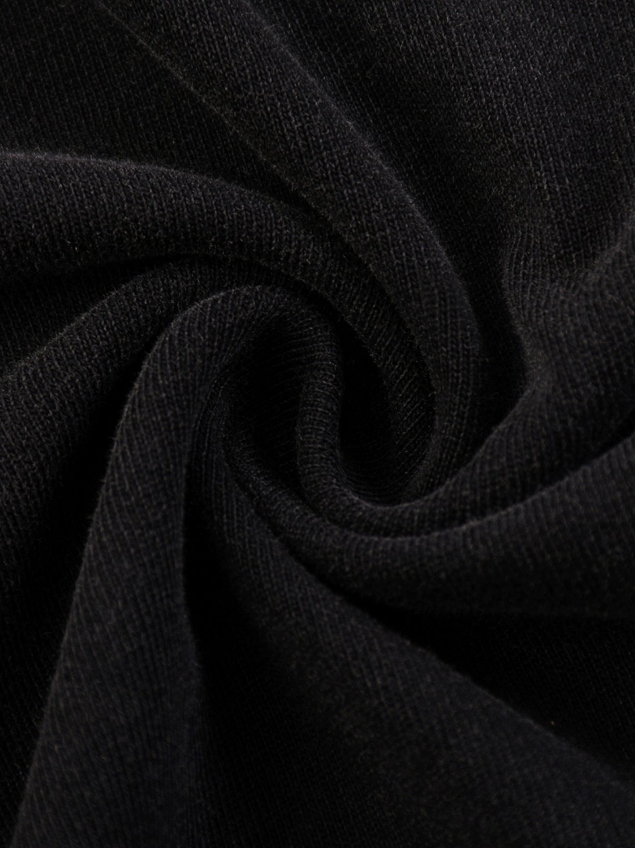 Close-up of black, soft, ribbed fabric from the Fusion Snow Washed Raw-Hem T-Shirt, arranged in a spiral to highlight its texture and gentle folds—an example of affordable luxury style.