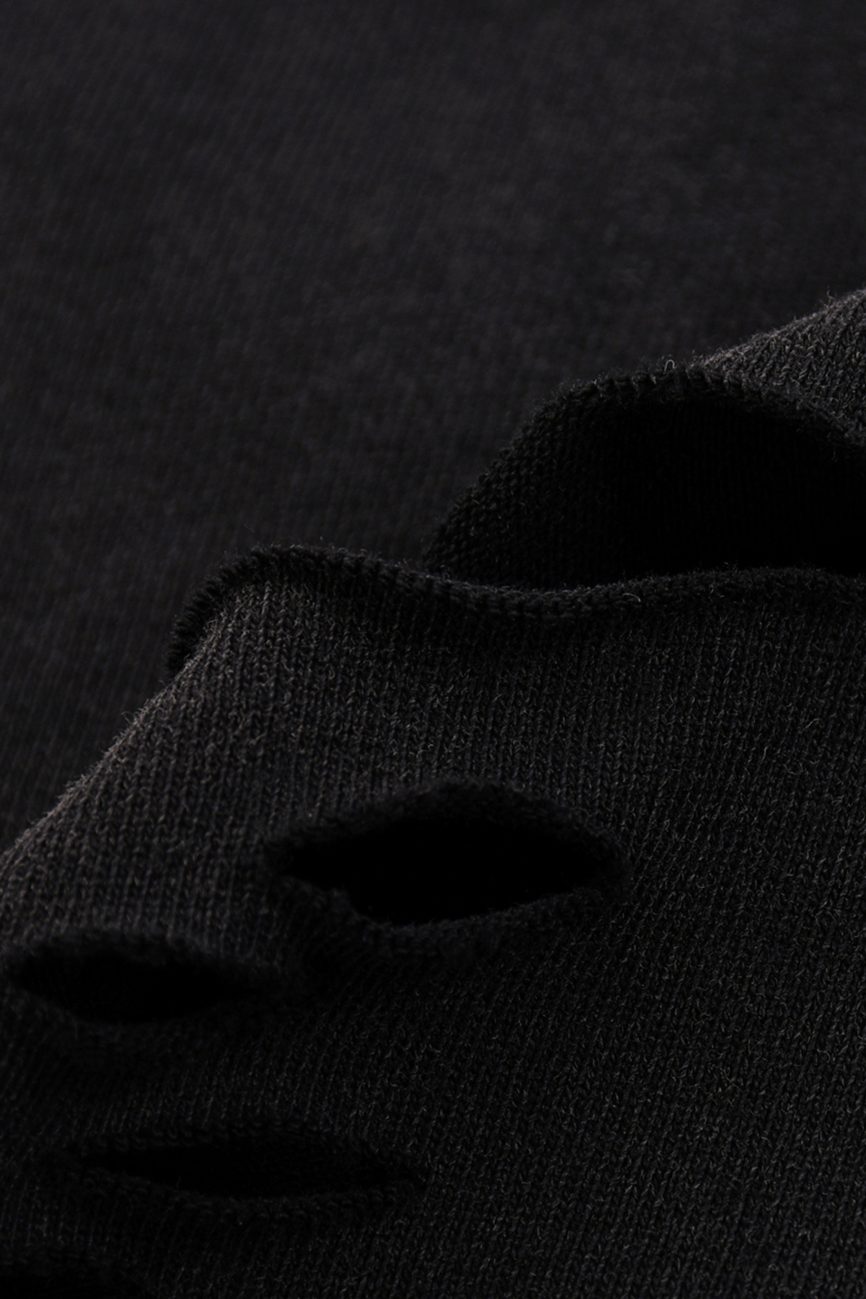 Close-up of black fabric from our Fusion Snow Washed Raw-Hem T-Shirt, showing several horizontal, frayed holes that reveal the torn edges and unique texture of the material.