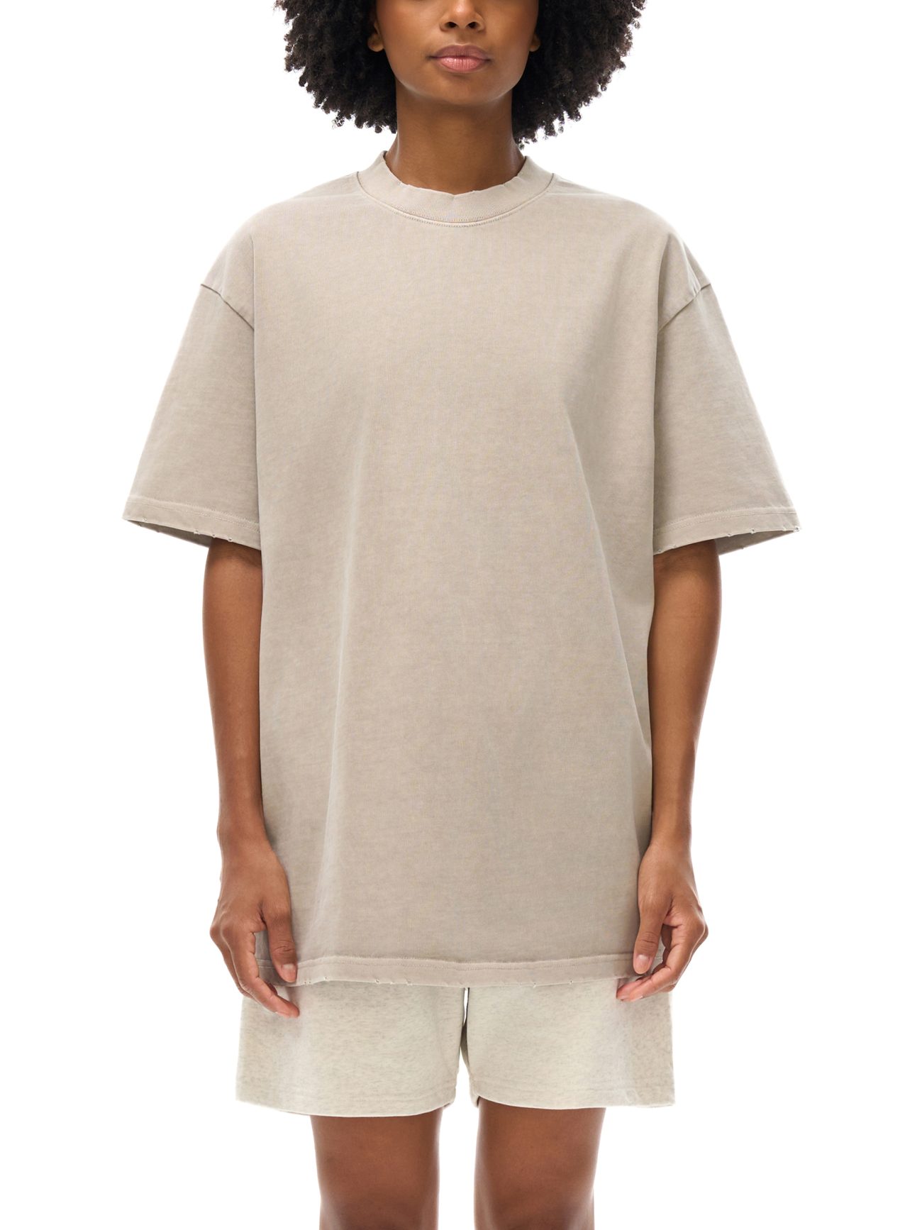 Wearing the Toile De Jouy - Heavyweight Vintage Washed Frayed T-Shirt, a person stands against a white background. Only their torso, arms, and upper legs are visible; hands rest relaxed by their sides.