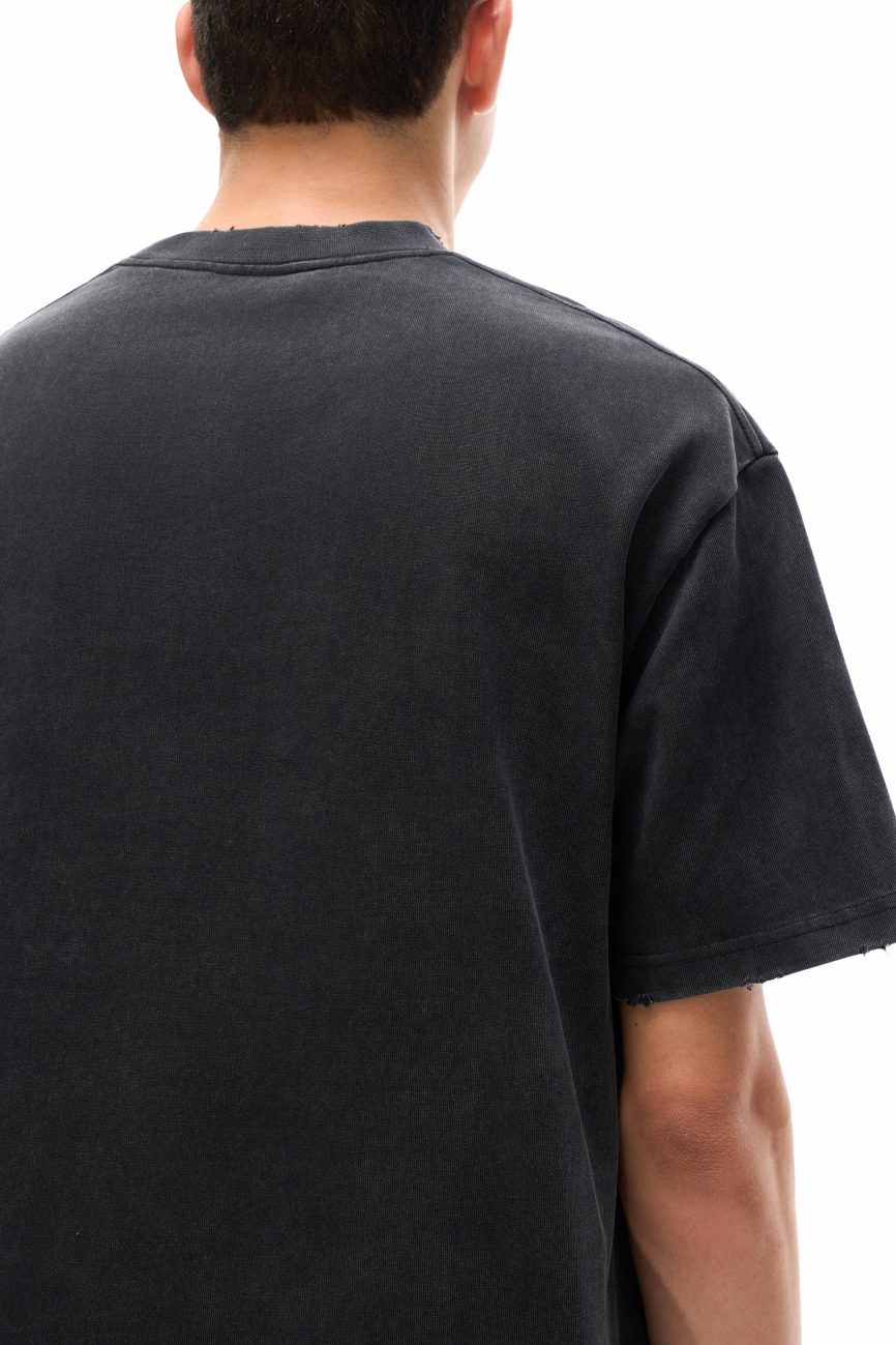 A person is shown from the back, wearing the Toile De Jouy - Heavyweight Vintage Washed Frayed T-Shirt in black, with short dark hair visible against a white background.