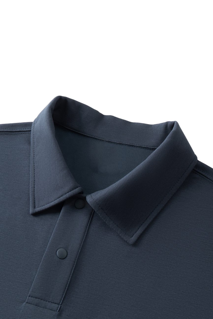 Close-up of the FC&Co. Drop Shoulder Short-Sleeve Polo in dark blue, showcasing a structured collar and two-button placket, displayed against a white background.