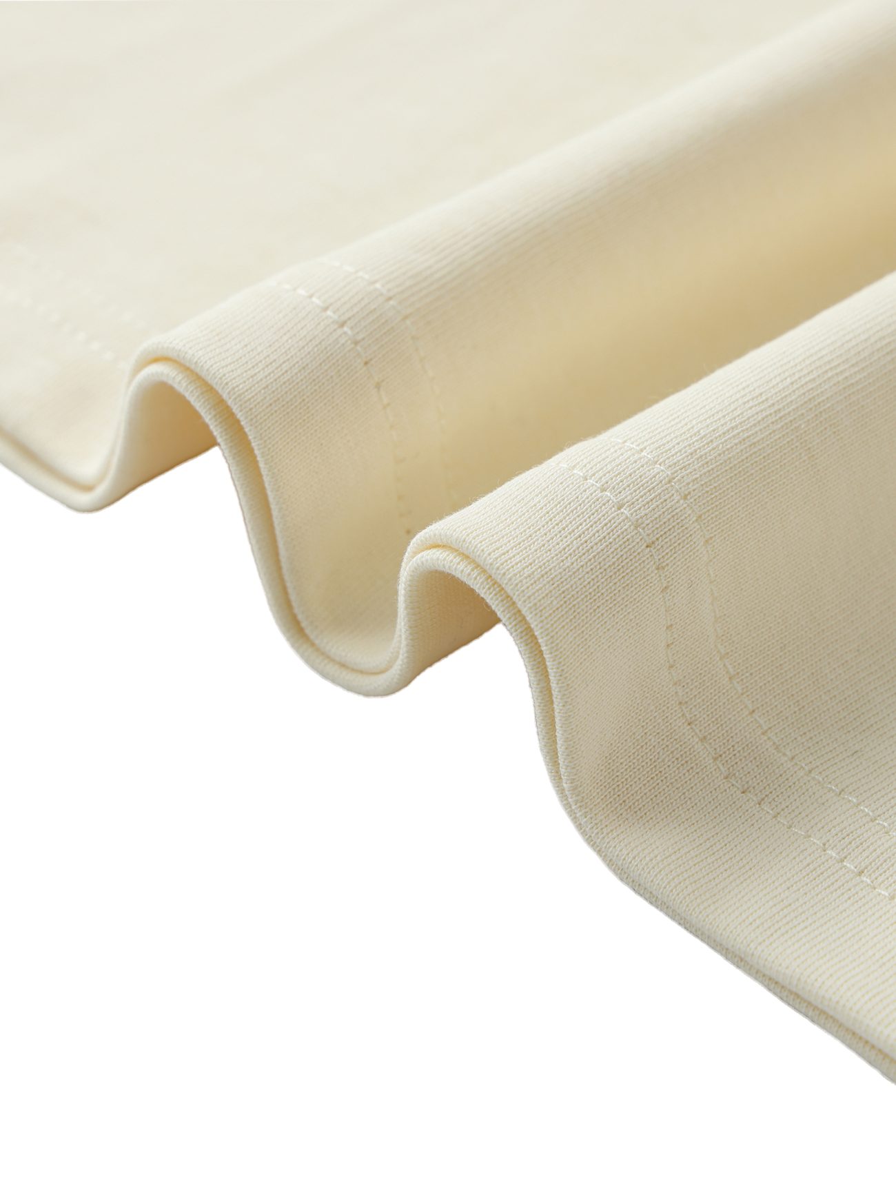 A close-up of the Crane Oversized Contrast-Stitched Cotton Tee in light beige, highlighting its visible edge stitching against a white background—an example of affordable luxury clothing.