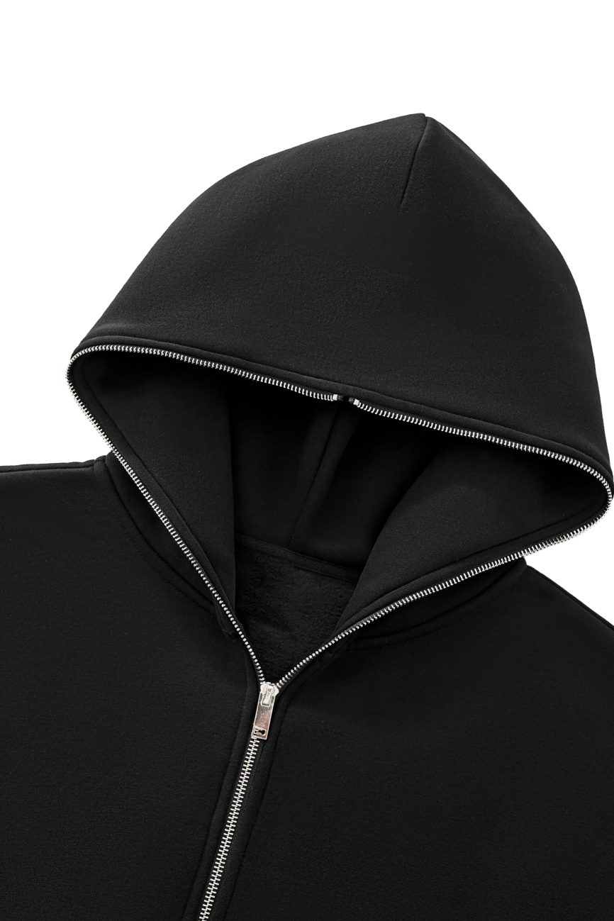 A close-up of the FC&Co. Fleeced Full-Zip Boxy Hoodie in black, featuring a silver zipper and partially unzipped, set against a white background.