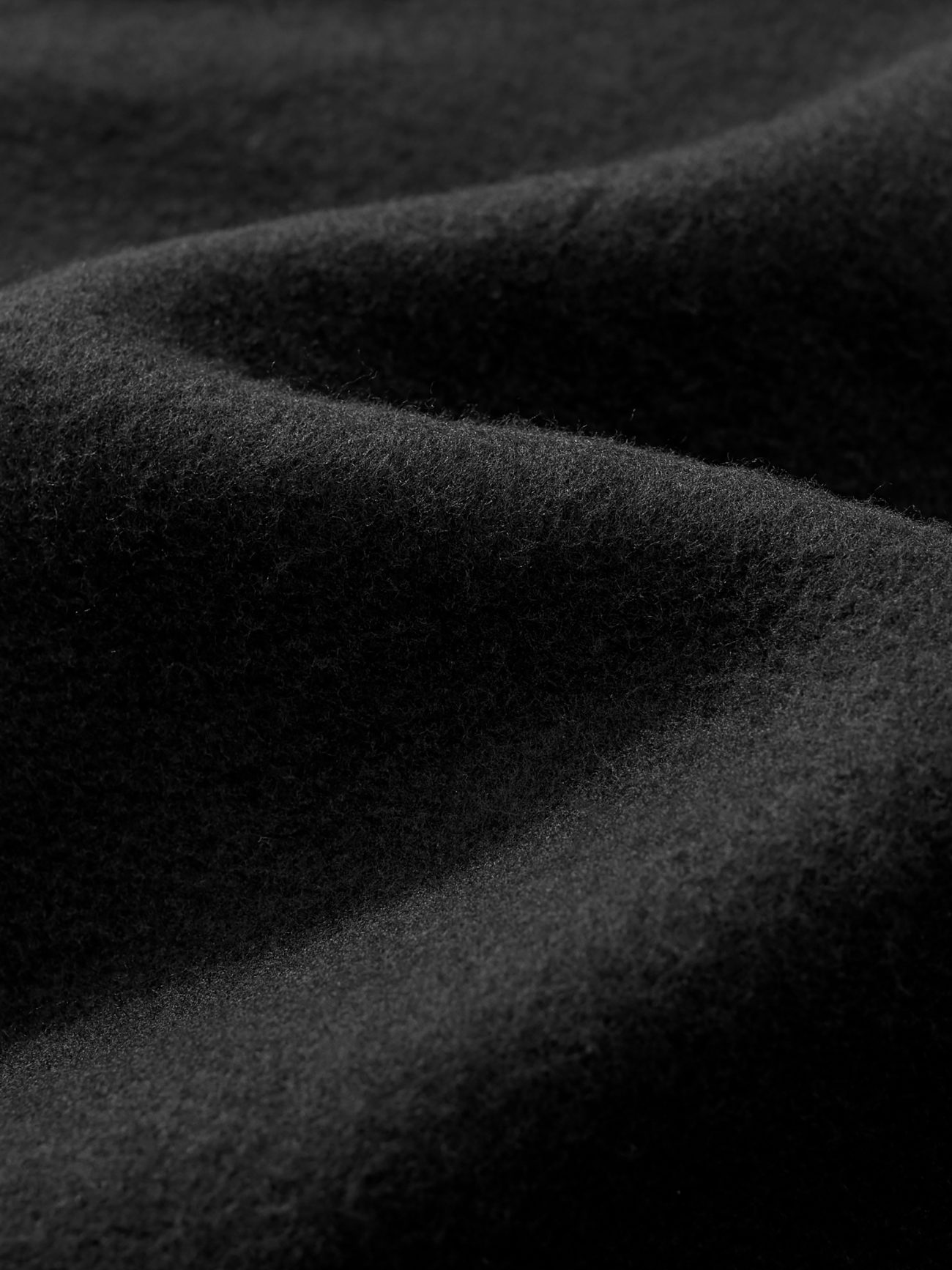 Close-up of the FC&Co. Fleeced Full-Zip Boxy Hoodie shows its soft black fleece with gentle folds and plush texture, highlighting the warmth and coziness of this affordable luxury piece.