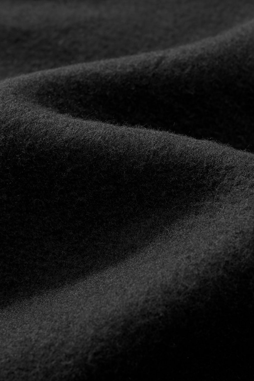 Close-up of the FC&Co. Fleeced Full-Zip Boxy Hoodie shows its soft black fleece with gentle folds and plush texture, highlighting the warmth and coziness of this affordable luxury piece.