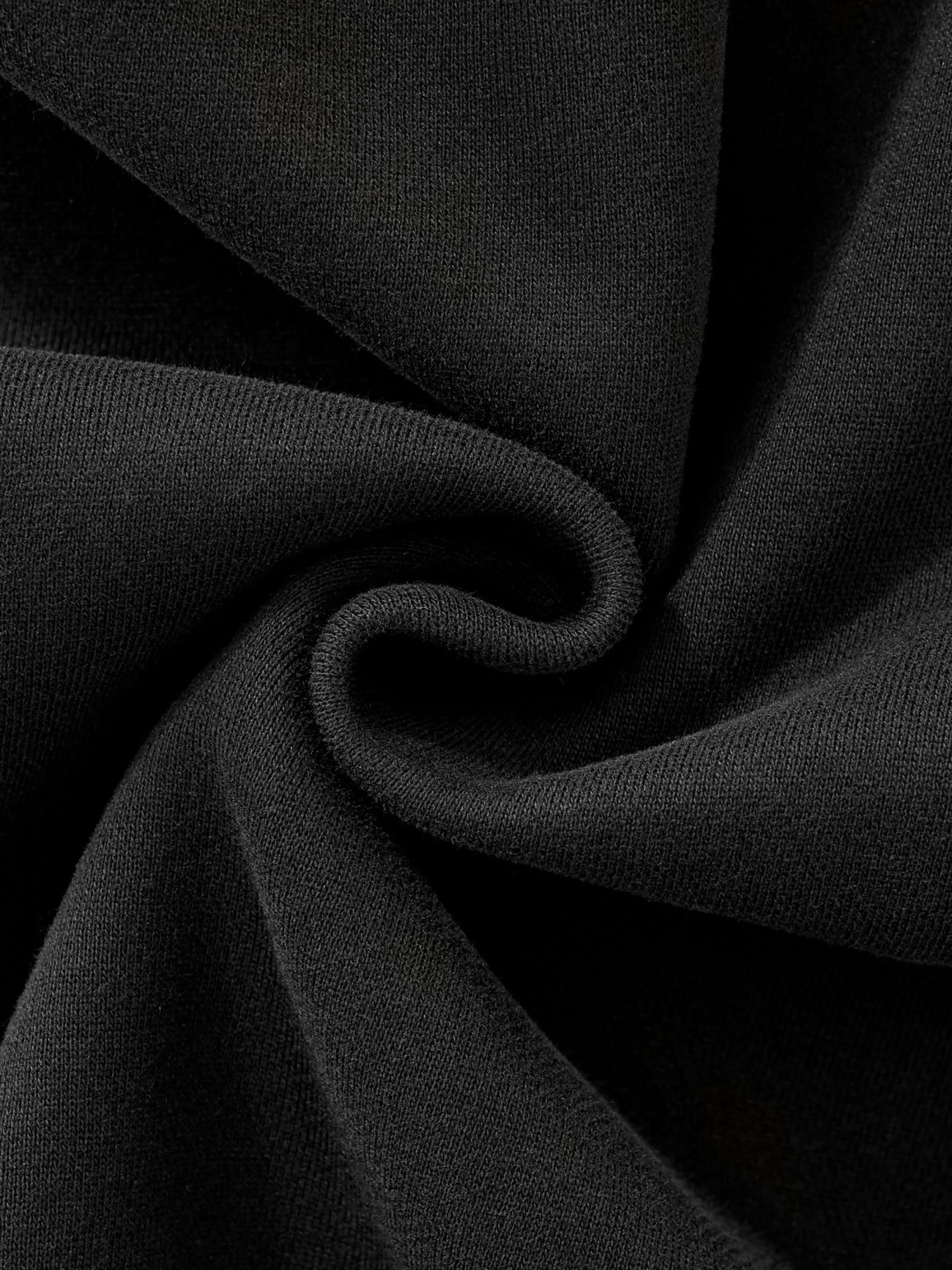 Close-up of the FC&Co. Fleeced Full-Zip Boxy Hoodie’s black fabric, twisted to highlight its soft texture and weave, showcasing the affordable luxury and comfy folds of this stylish hoodie.