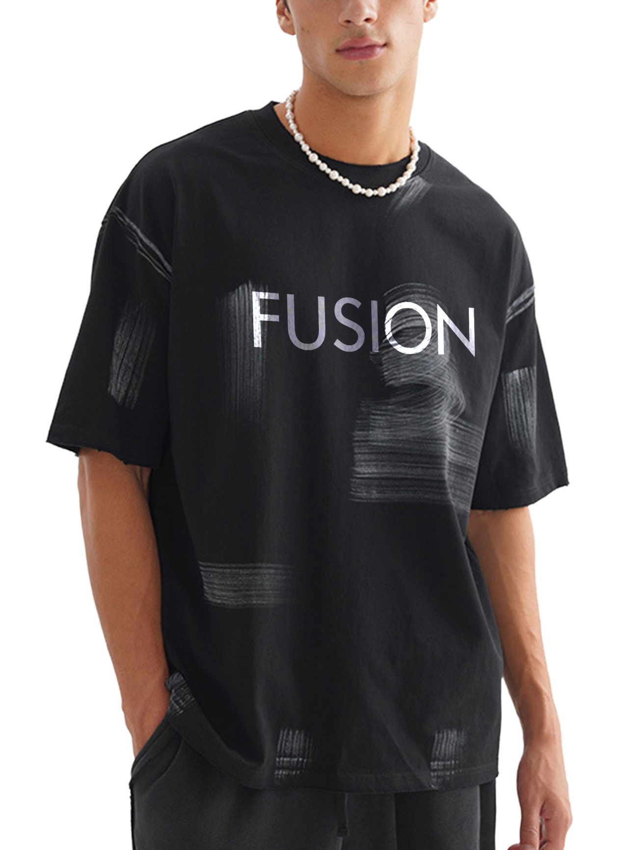 A person wearing the Hand Brushed T-shirt—an affordable luxury black tee with white brushstroke patterns and FUSION boldly printed across the chest—paired with a beaded necklace.